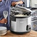 A woman using a Galaxy commercial rice cooker to cook rice.