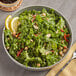 A bowl of fresh kale salad with lemon slices.