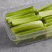 A container of fresh celery sticks on a table.