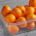 A clear plastic container filled with Fresh Clementines on a table.