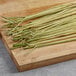 Fresh lemongrass stalks on a wooden cutting board.