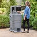 A woman using a Lavex mobile hand wash station with foaming soap and paper towel dispensers.