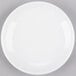 A Libbey Porcelana bright white porcelain coupe plate on a gray surface.