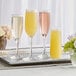 A tray with three Libbey Vina champagne flutes with flowers in them.