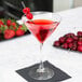 A Libbey Vina martini glass filled with red liquid and cherries on top.