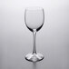 A clear Libbey Vina tall wine glass on a white surface.