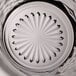 A clear glass with a decorative, textured base featuring a radial pattern.