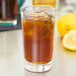 A Libbey highball glass of iced tea with lemon and ice.