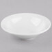 A Libbey Porcelana bright white porcelain grapefruit bowl on a gray surface.