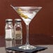 A Libbey Vina martini glass with olives on a table.