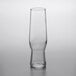 A Libbey clear flute glass with a small amount of liquid in it.