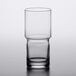 A close-up of a Libbey Newton stackable beverage glass filled halfway with a clear beverage.