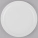 A Libbey Porcelana bright white round narrow rim porcelain plate on a gray surface.