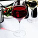 A Reserve by Libbey Prism red wine glass full of red wine on a table with a salad.