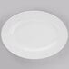 A Libbey Porcelana bright white oval porcelain platter on a gray surface.