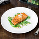 A Libbey Porcelana round white porcelain coupe plate with salmon and green beans.