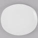 A Libbey Porcelana white porcelain coupe plate on a gray surface.