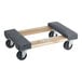 A wooden dolly with carpeted deck ends and black wheels.