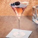 A Reserve by Libbey Renaissance martini glass with a pink drink and blackberries on the table.