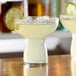 Two Libbey Symbio cocktail glasses filled with a drink and garnished with a lime wedge.