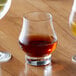 A Reserve by Libbey Circa whiskey glass filled with brown liquid on a table.