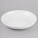 A Libbey Porcelana bright white porcelain low bowl on a gray surface.