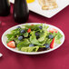 A Libbey oval coupe platter with salad, strawberries, and blueberries.