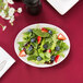 A Libbey white oval platter with a salad of greens, strawberries, and blueberries.