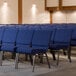 A row of Lancaster Table & Seating church chairs with blue fabric.