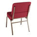 A Lancaster Table & Seating church chair with a burgundy seat and gold legs.