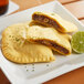 Two unbaked Caribbean Food Delights Jerk BBQ Jackfruit patties on a plate.