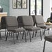 A room with Lancaster Table & Seating Silver Vein Church Chairs with gray fabric.