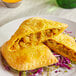 A plate topped with a Caribbean Food Delights Unbaked Jackfruit Curry Patty.