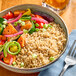 A bowl of Parboiled Brown Rice and vegetables with a fork.