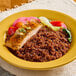 A bowl of red quinoa on a table with a fork.