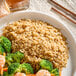 A plate of Long Grain Brown Rice with shrimp and broccoli.