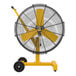 A yellow and black Big Ass Fans AirEye Low Rider pedestal fan with black wheels.