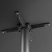A metal pole with a black metal table base plate and spider.