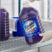 A person holding a large purple bottle of Fabuloso lavender-scented multi-purpose cleaner.