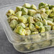 A plastic container with Simplot Harvest Fresh IQF diced avocado in it.