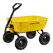 A yellow steel dump cart with black handles and wheels.