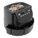 A black Cassida coin counting machine with coins in it and a LED digital display.