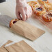 A person putting a pastry in a customizable Kraft gourmet bag.