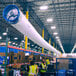 A large white fabric air duct with a man in a yellow safety vest.