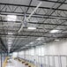 A large white Patterson V-Series 12' HVLS ceiling fan installed in a warehouse.