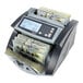 A Cassida 5520 bill counting machine with a digital display counting cash.