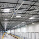 A large white Patterson V-Series HVLS ceiling fan installed in a warehouse.