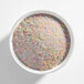 A bowl filled with fine pastel rainbow sanding sugar.
