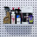 A white steel Triton Products shelf holding bottles of cleaning products.