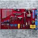 A red Triton LocBoard with tools hanging on it.